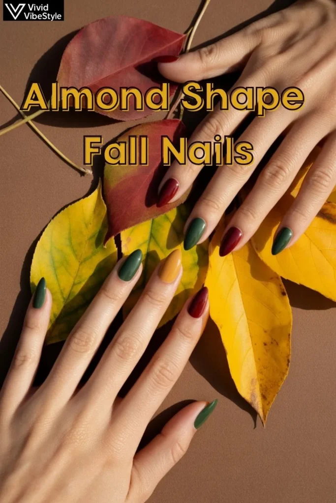 Almond shaped nails painted in fall colors—forest green, maroon, and mustard yellow—styled with autumn leaves