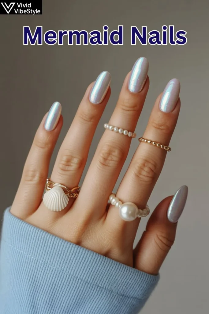 Short natural mermaid nails with iridescent polish, seashell accents, and pearls for an elegant ocean-inspired manicure.
