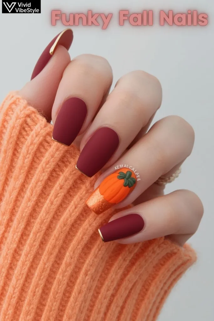 Funky fall nails with texture contrast—matte burgundy nails, glossy gold accents, and a 3D pumpkin nail design styled with a knit scarf